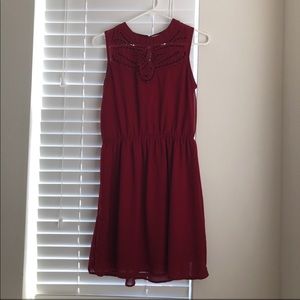 Dark red, sleeveless dress w/ chest design.